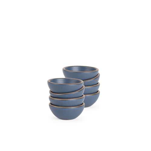 A stack of 8 tiny rounded ceramic bowls in a cool, medium blue color featuring iron speckles and an unglazed rim
