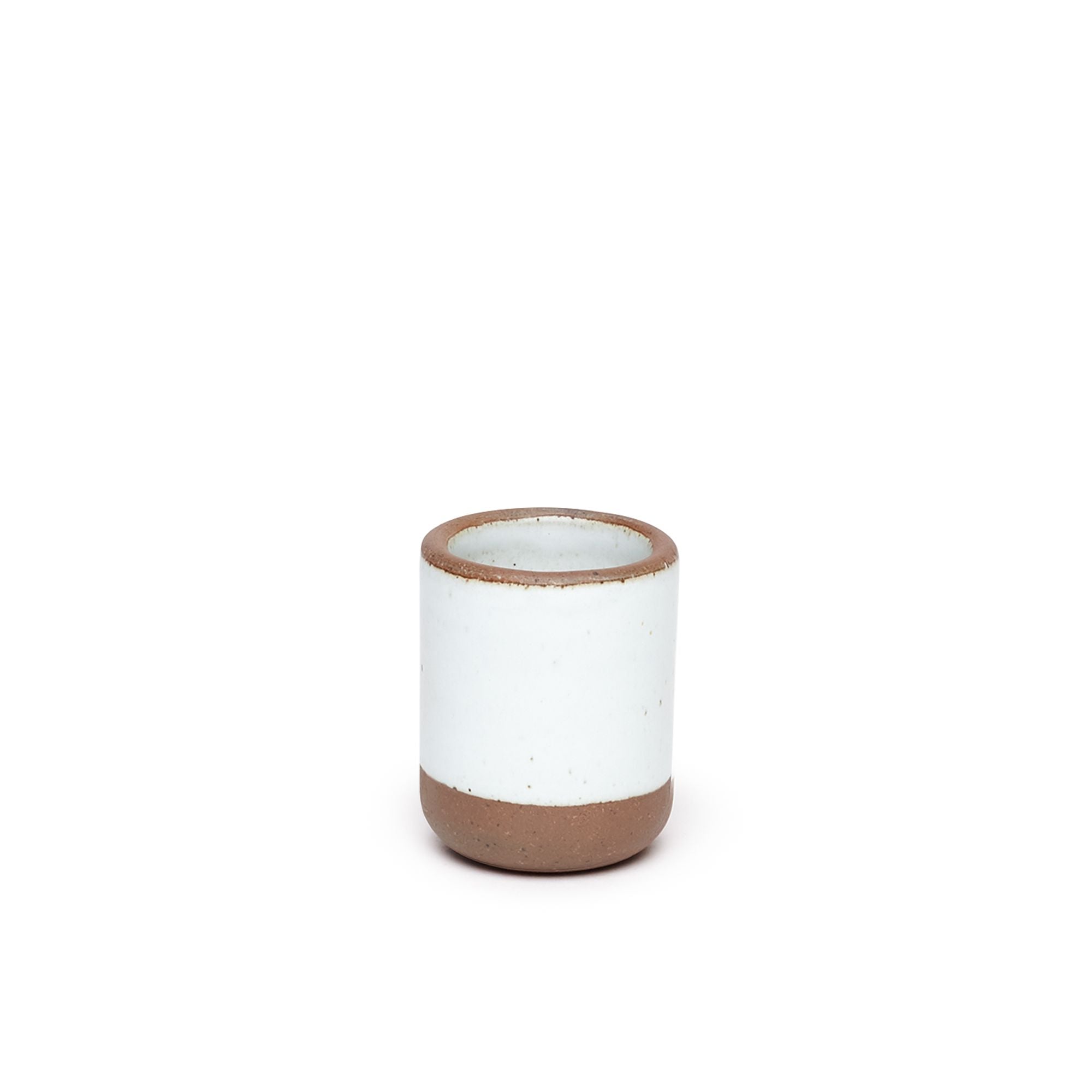 A short ceramic cup in a cool white color featuring iron speckles and unglazed rim.