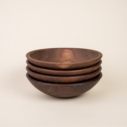 A stack of 4 small walnut wood bowls