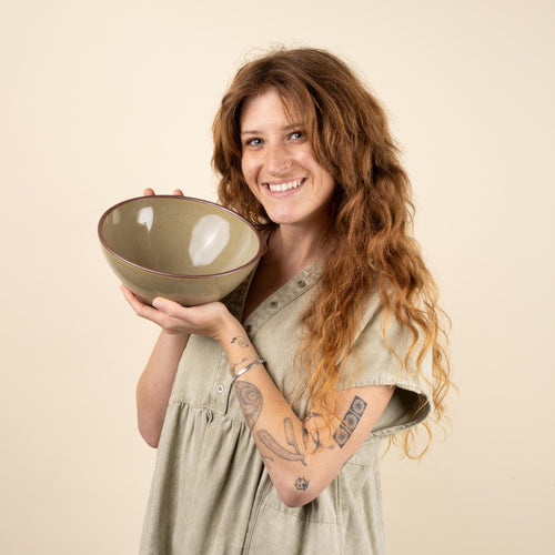 Layson smiling and holding a large round popcorn bowl in a dappled grey-green color.