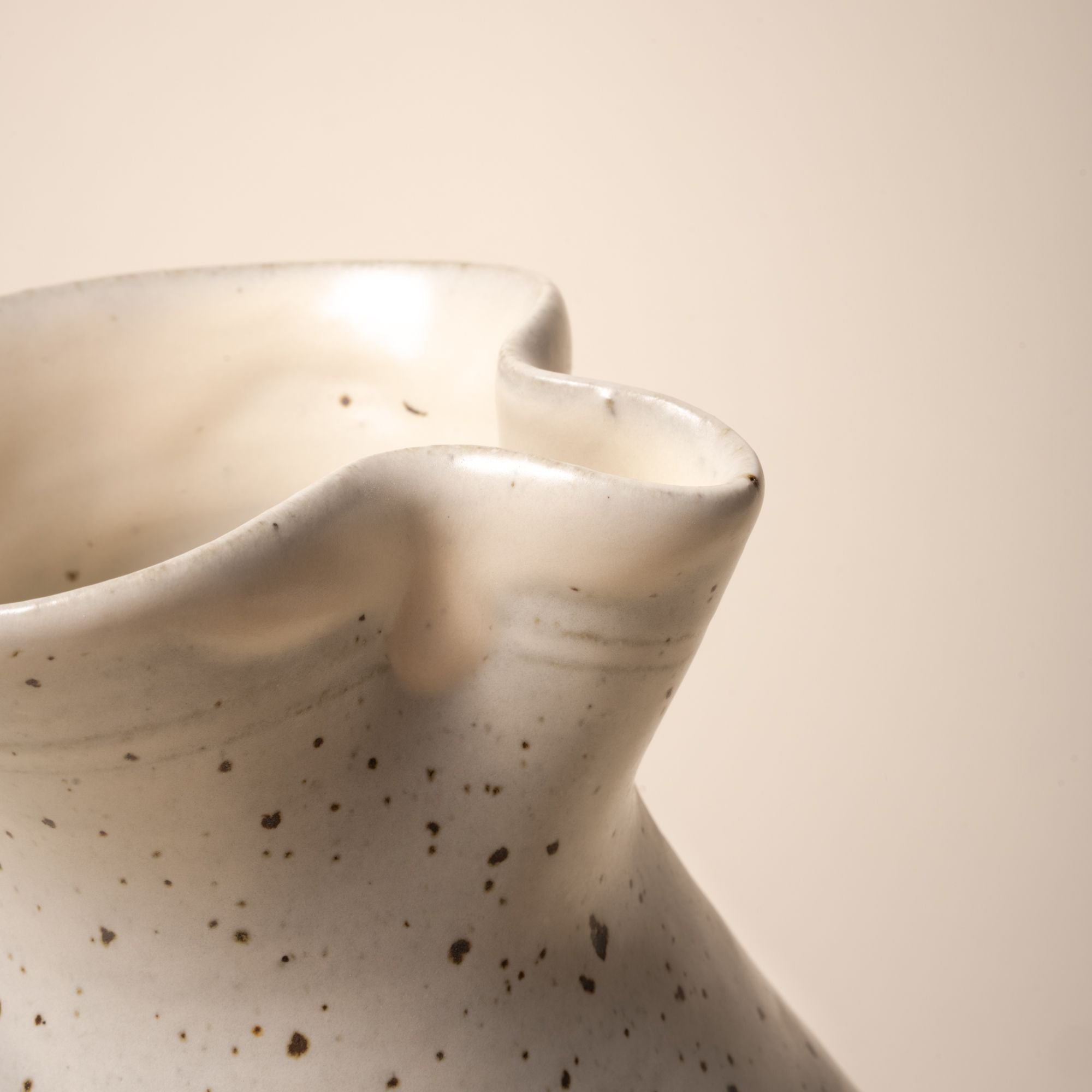 A closeup of the hand-formed spout a the topof a ceramic pitcher.