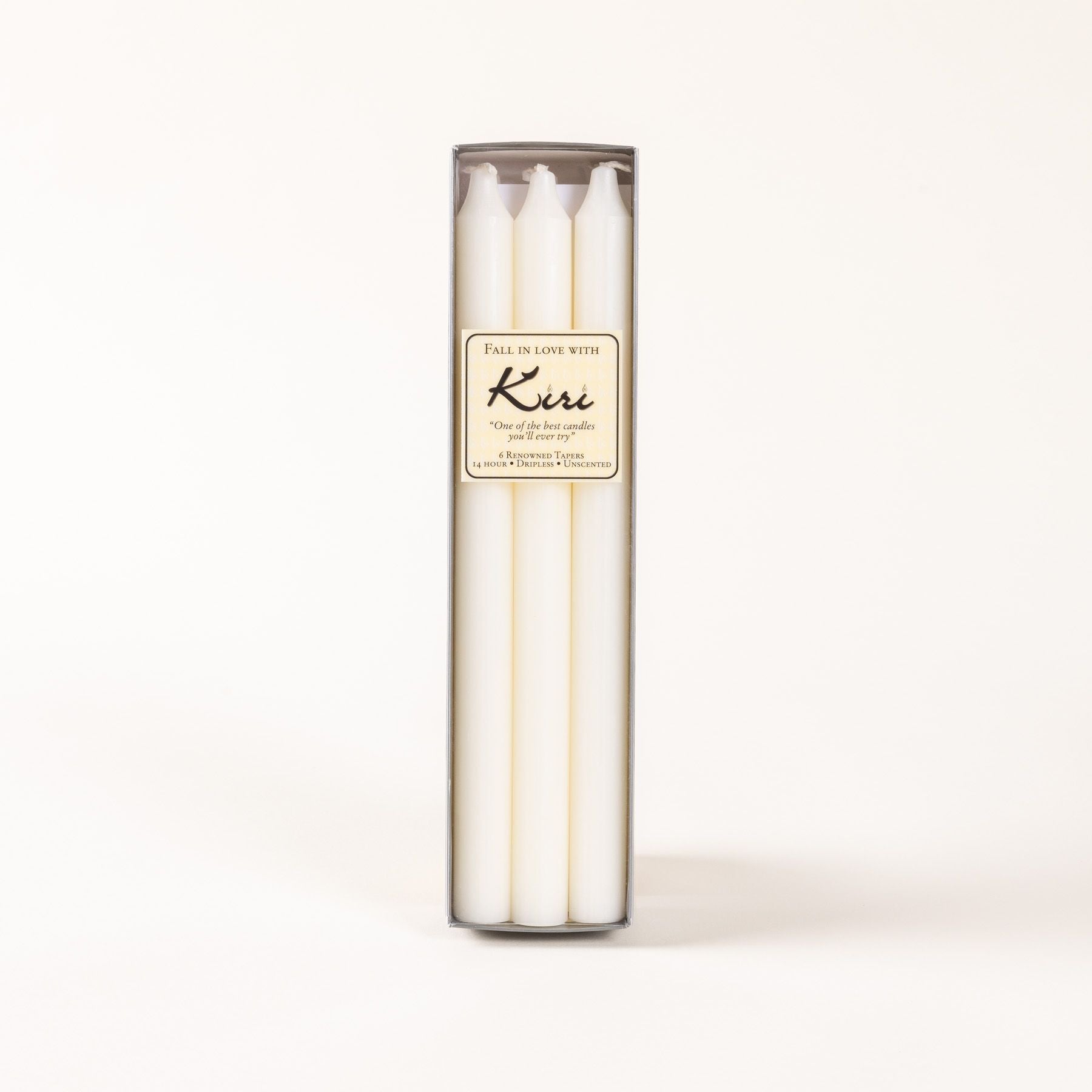 A narrow box of white taper candles with a cream label.