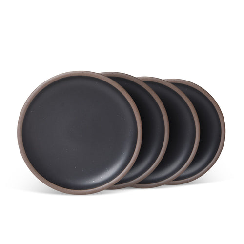 4 medium sized ceramic plates in a graphite black color featuring iron speckles and an unglazed rim.