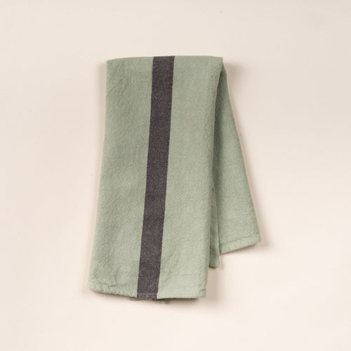 A folded linen towel in a light green color with a dark grey stripe in the middle