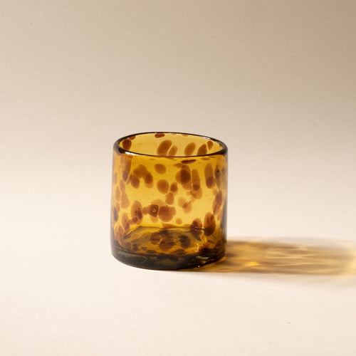 A tortoiseshell short transparent drinking glass