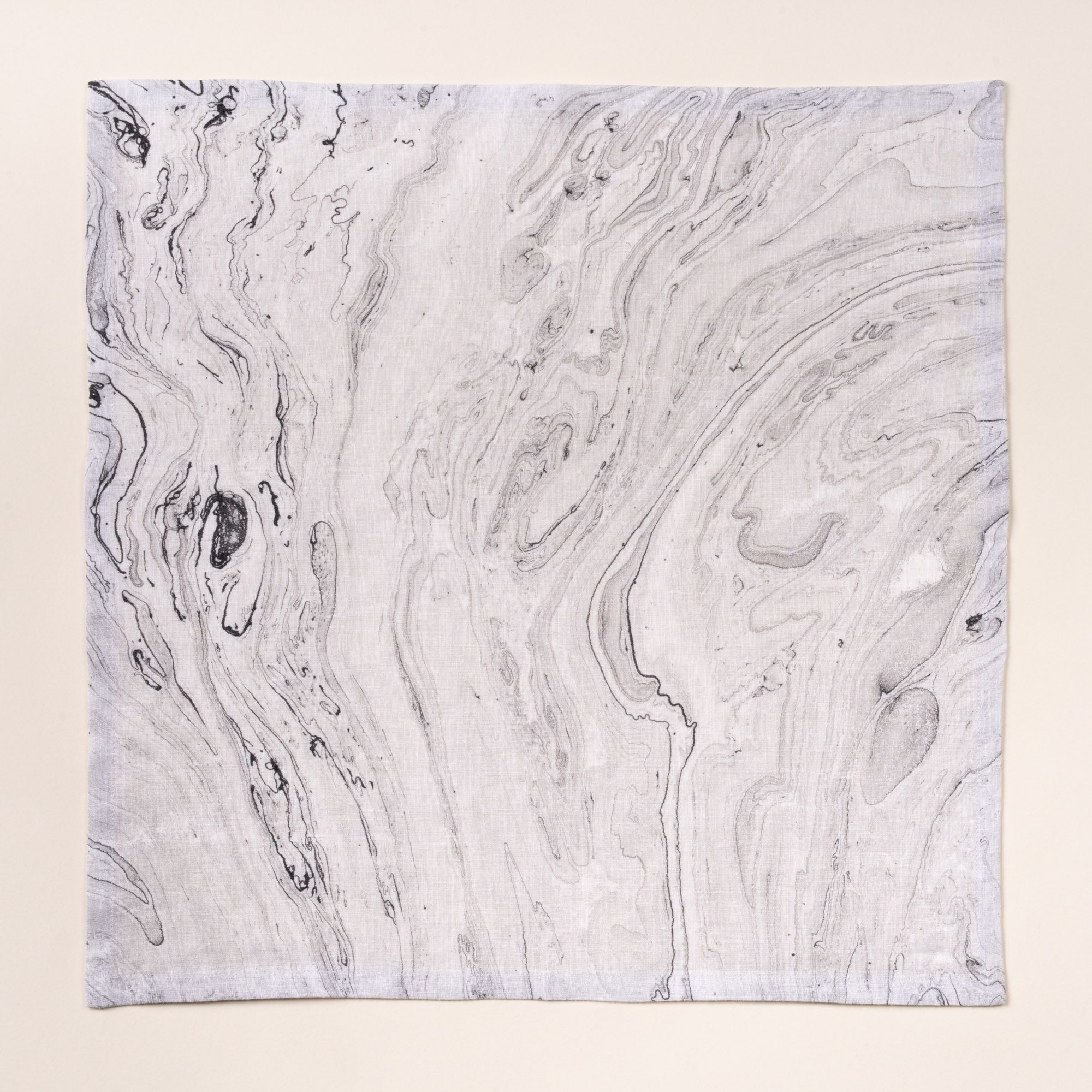 Gray marbled cloth napkin with swirling stone-like pattern on a light background.