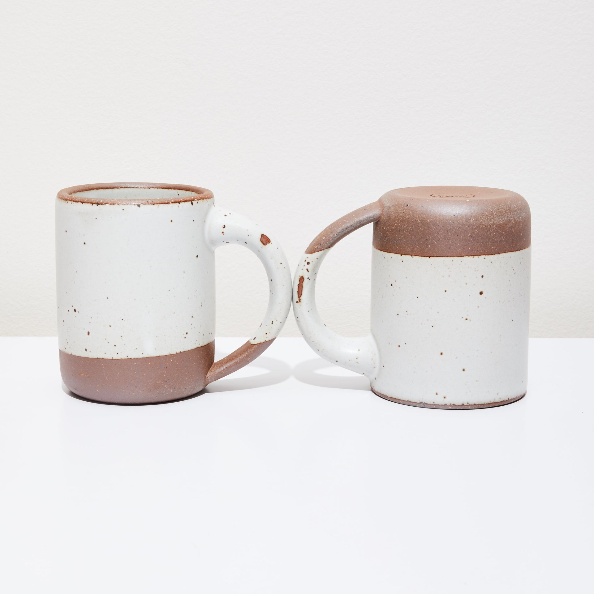 Two ceramic mugs with some aesthetic flaws.