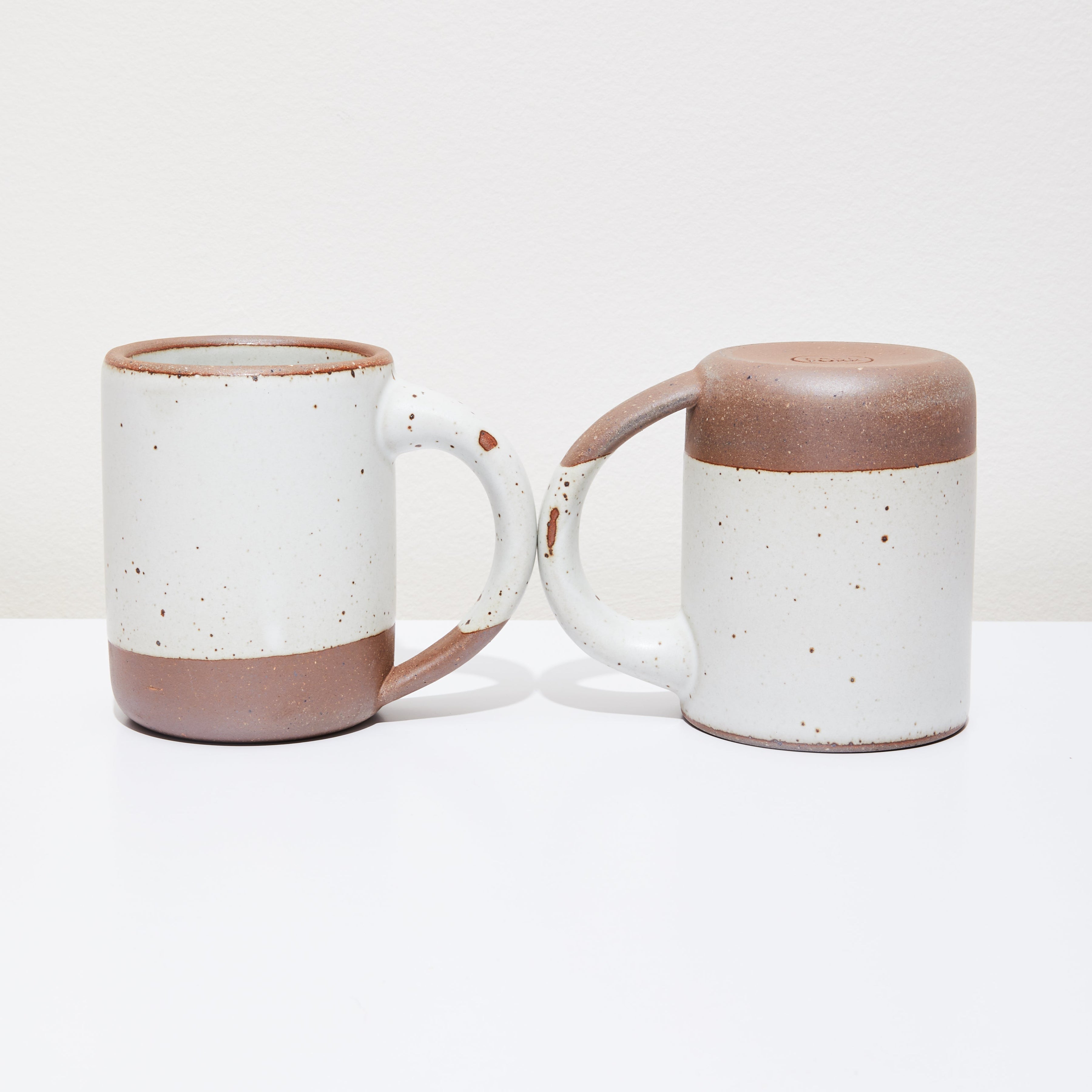 Two ceramic mugs with some aesthetic flaws.