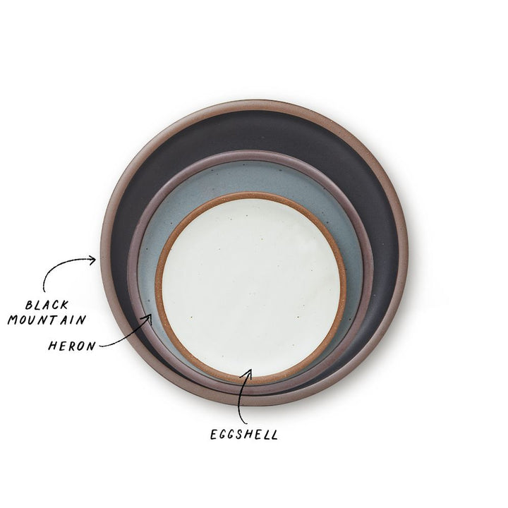 A stack of 3 plates in Dinner, Side, and Cake sizes in a graphite black, blue-grey, and cool white colors.