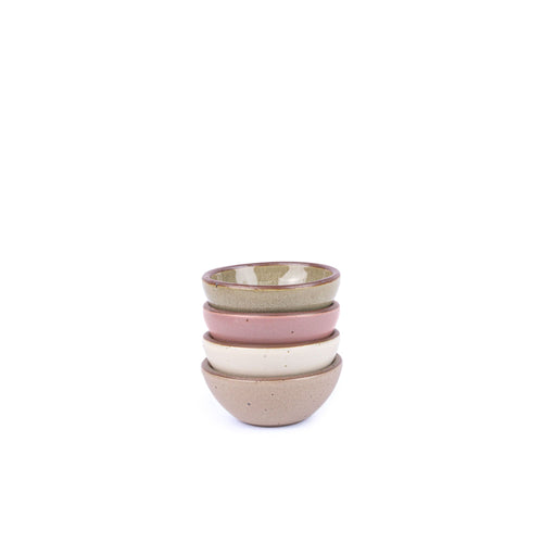A stack of 4 tiny rounded ceramic bowls in a reflective dappled grey-green, warm off-white, warm pale brown and dusty mauve pink featuring iron speckles and an unglazed rim