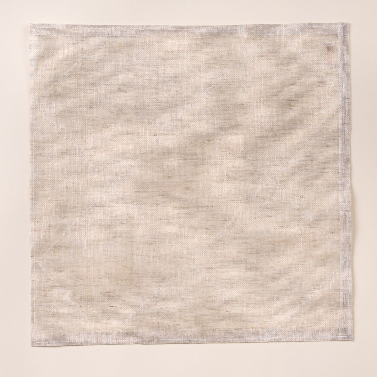 Square natural linen cleaning cloth laid flat on a light background, showing a subtle woven texture and stitched edges.