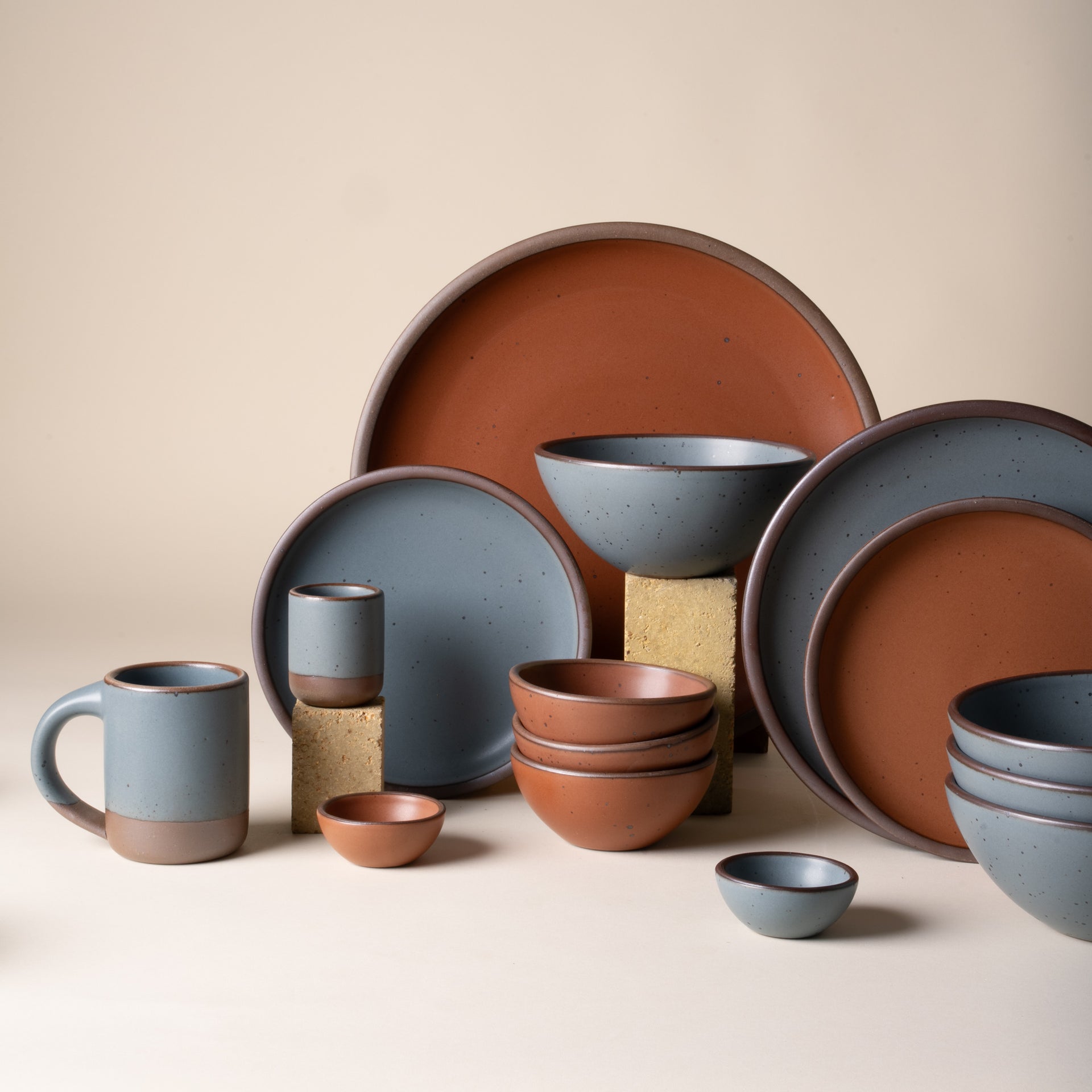 Set of ceramic dishes in brown and blue on a beige background
