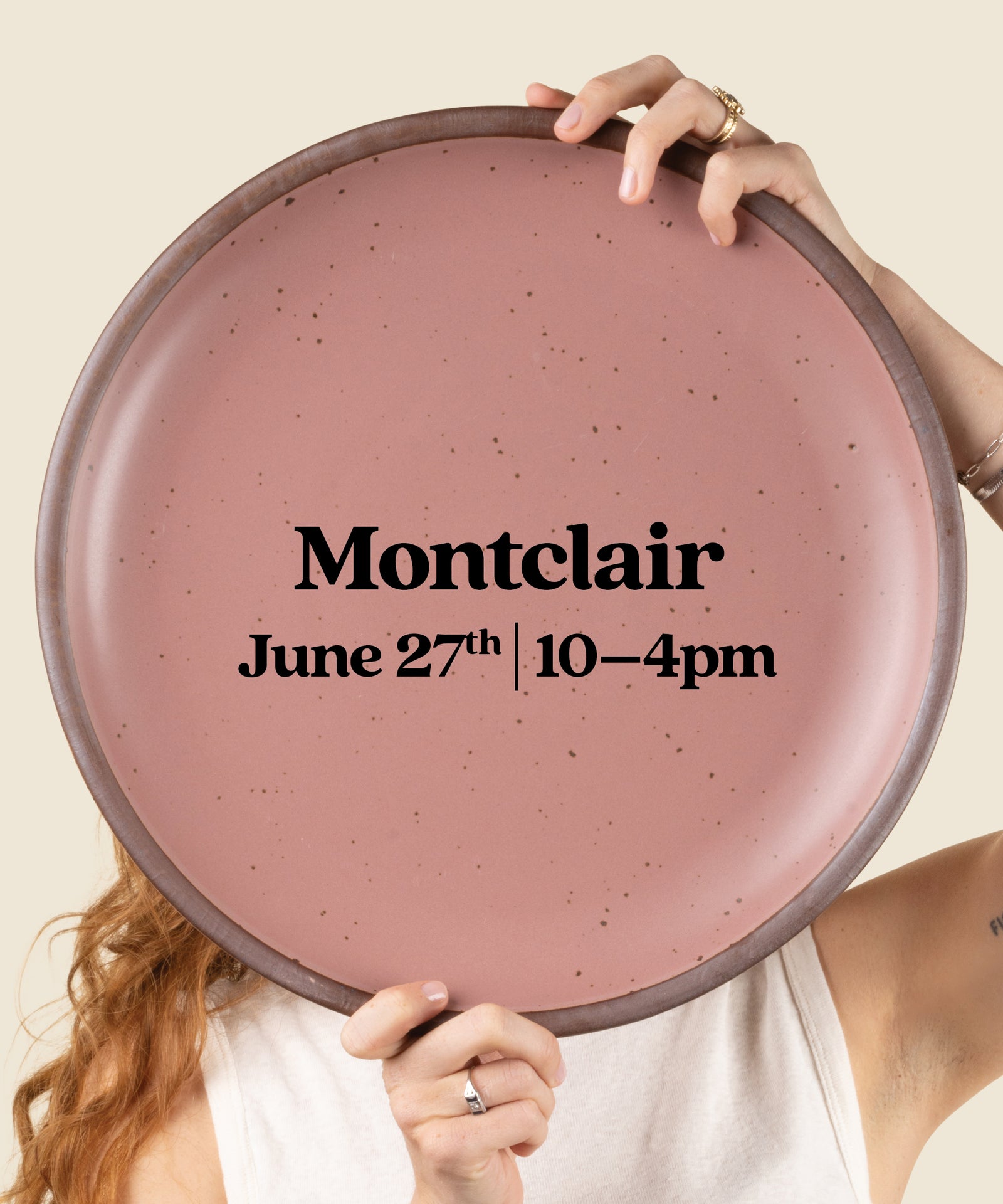 Person holding a pink plate with 'Montclair' event details on a beige background