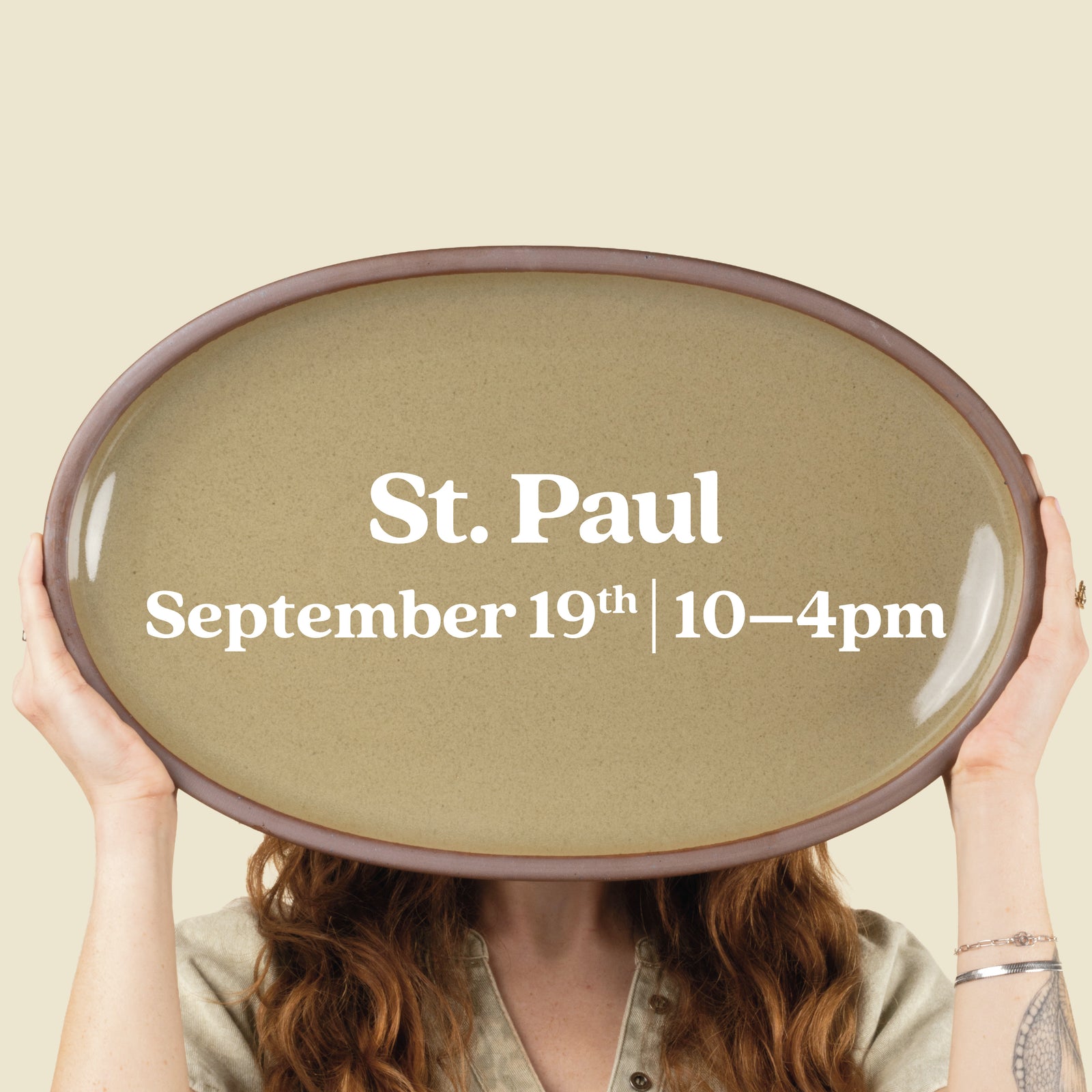 Person holds up a large oval platter with text overlay that reads "St. Paul September 19th 10-4pm"