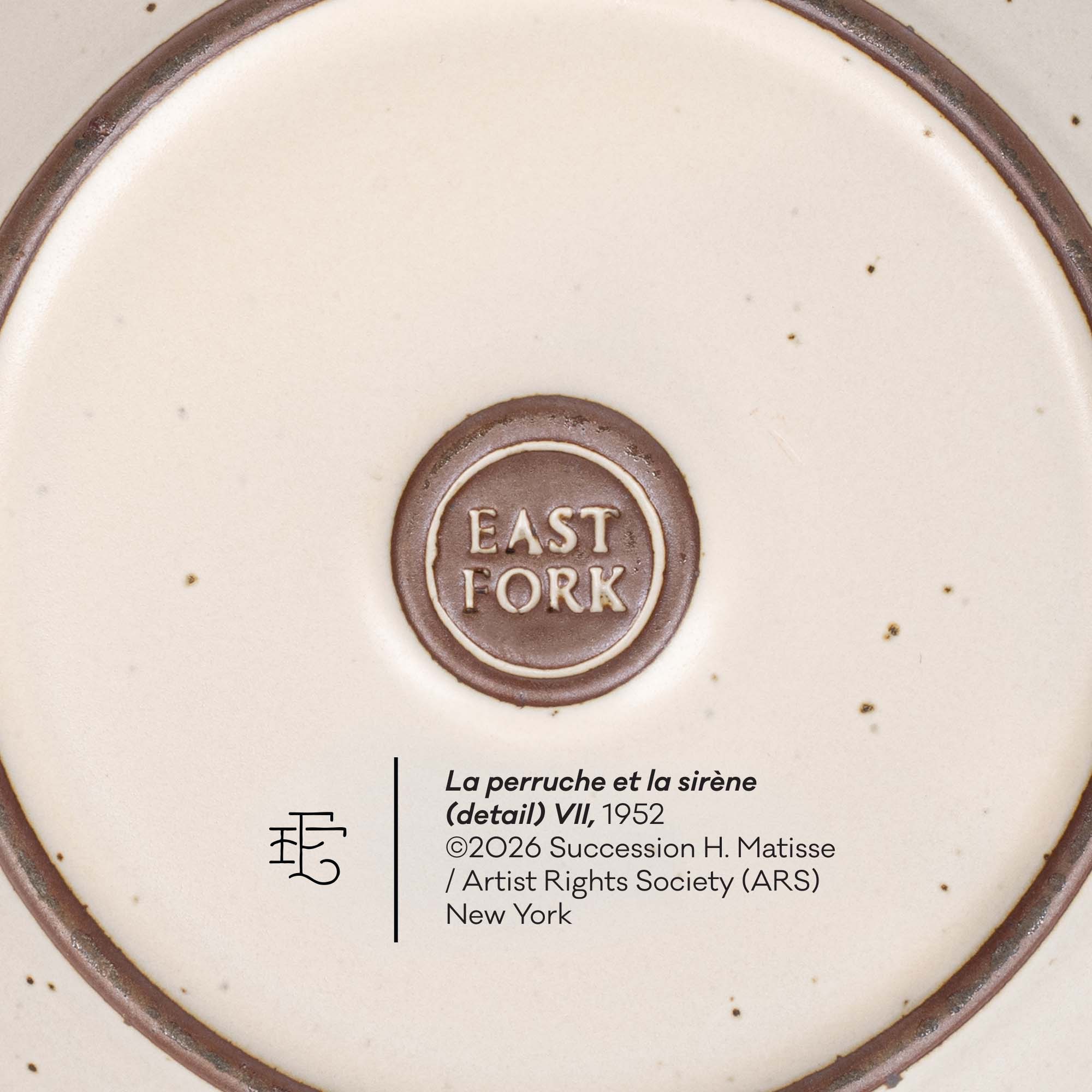 Close-up detail of a ceramic plate or dish base showing the brand mark 'EAST FORK' in a circular brown emblem, alongside printed text including 'La perruche et la sirène (detail) VII, 1952' and 'New York'.