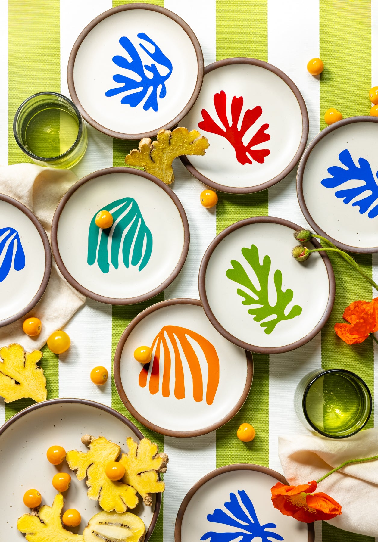 An overhead view of La Perruche Cake Plates styled with various fruits and orange flowers.