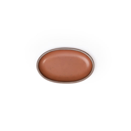 A small oval ceramic platter in a cool terracotta color featuring iron speckles and an unglazed rim