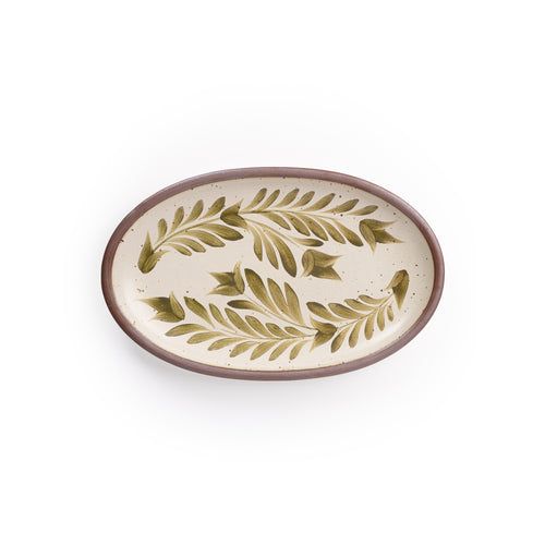 A medium oval ceramic platter in a warm, tan-toned, off-white color featuring iron speckles and an unglazed rim, with handpainted greenery in an olive green color.