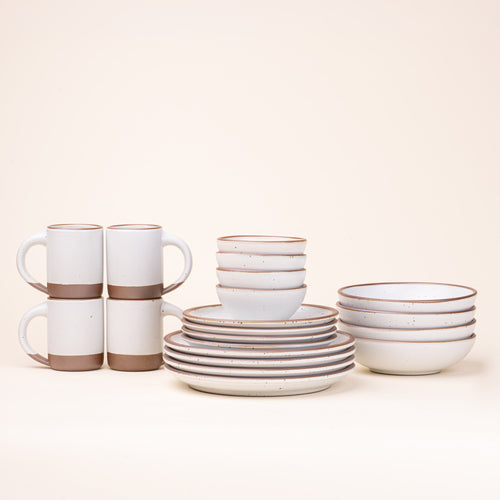 A 20-piece set of ceramic tableware, including mugs, bowls, and plates in a cool white color.