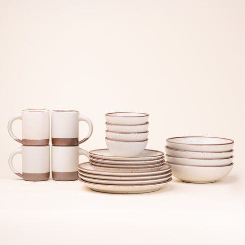 A 20-piece set of ceramic tableware, including mugs, bowls, and plates in a warm off-white color.