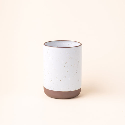A cylindrical ceramic utensil crock and an unglazed base, in a cool white color.