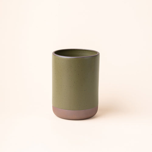 A cylindrical ceramic utensil crock and an unglazed base, in an olive green color.