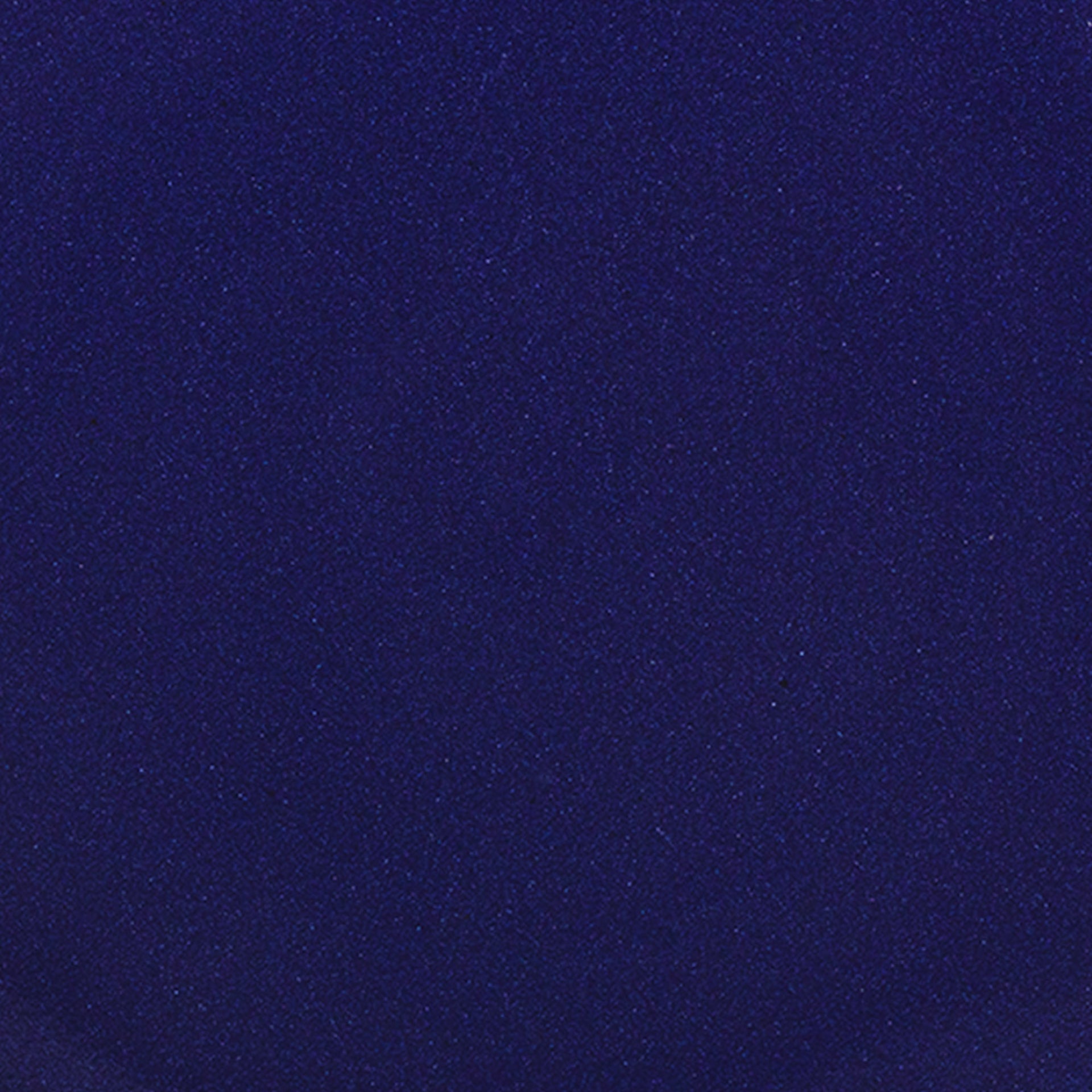 A closeup of a ceramic plate in a glossy dark blue color with iron spots