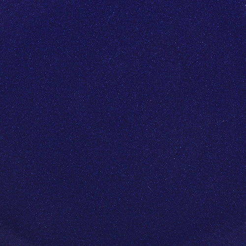 A closeup of a ceramic plate in a glossy dark blue color with iron spots