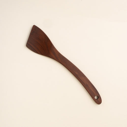 Black walnut wood spatula with a slanted head and a hole at the bottom 