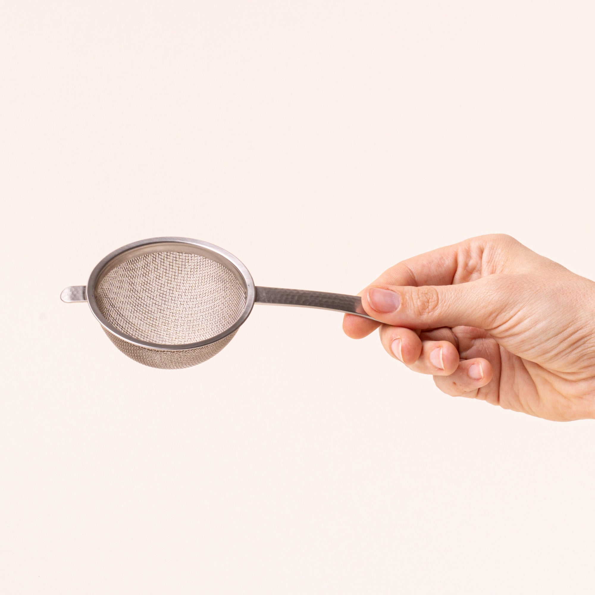 Hand holding handle of Stainless steel half dome strainer with steel handle