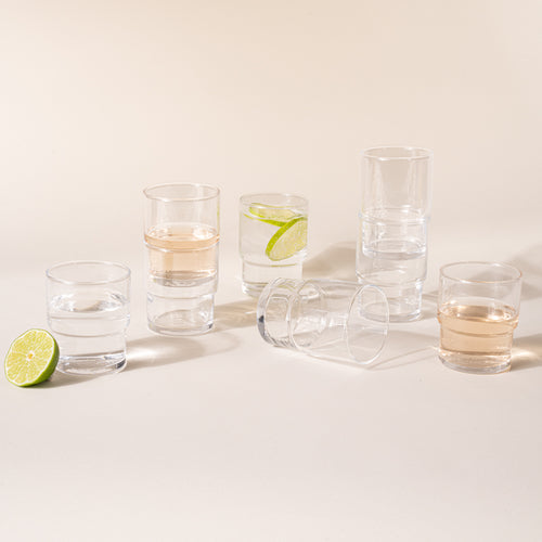 Several stacking glasses in small and medium glasses filled with drinks and artfully arranged.