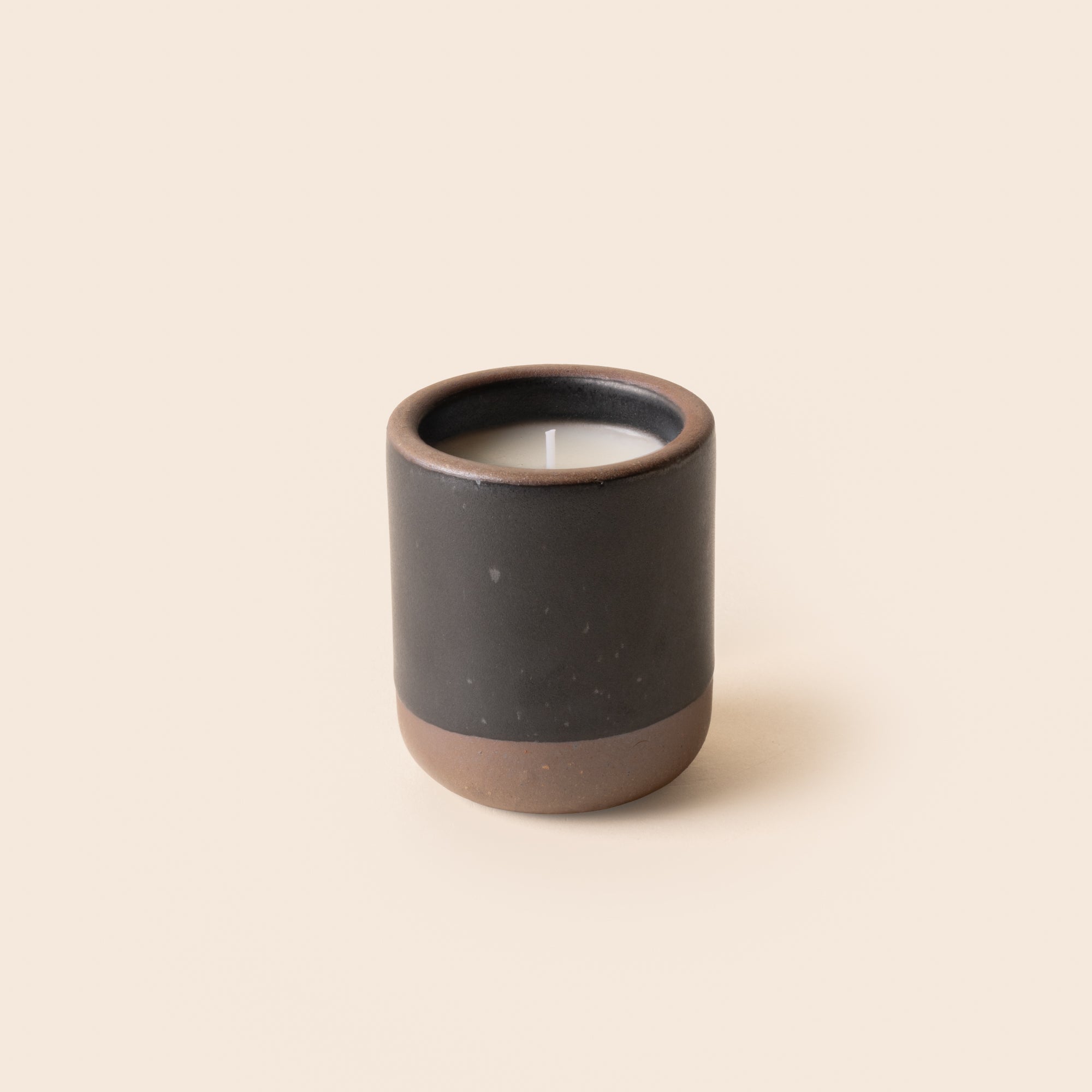 Small ceramic vessel in a black color with candle inside.