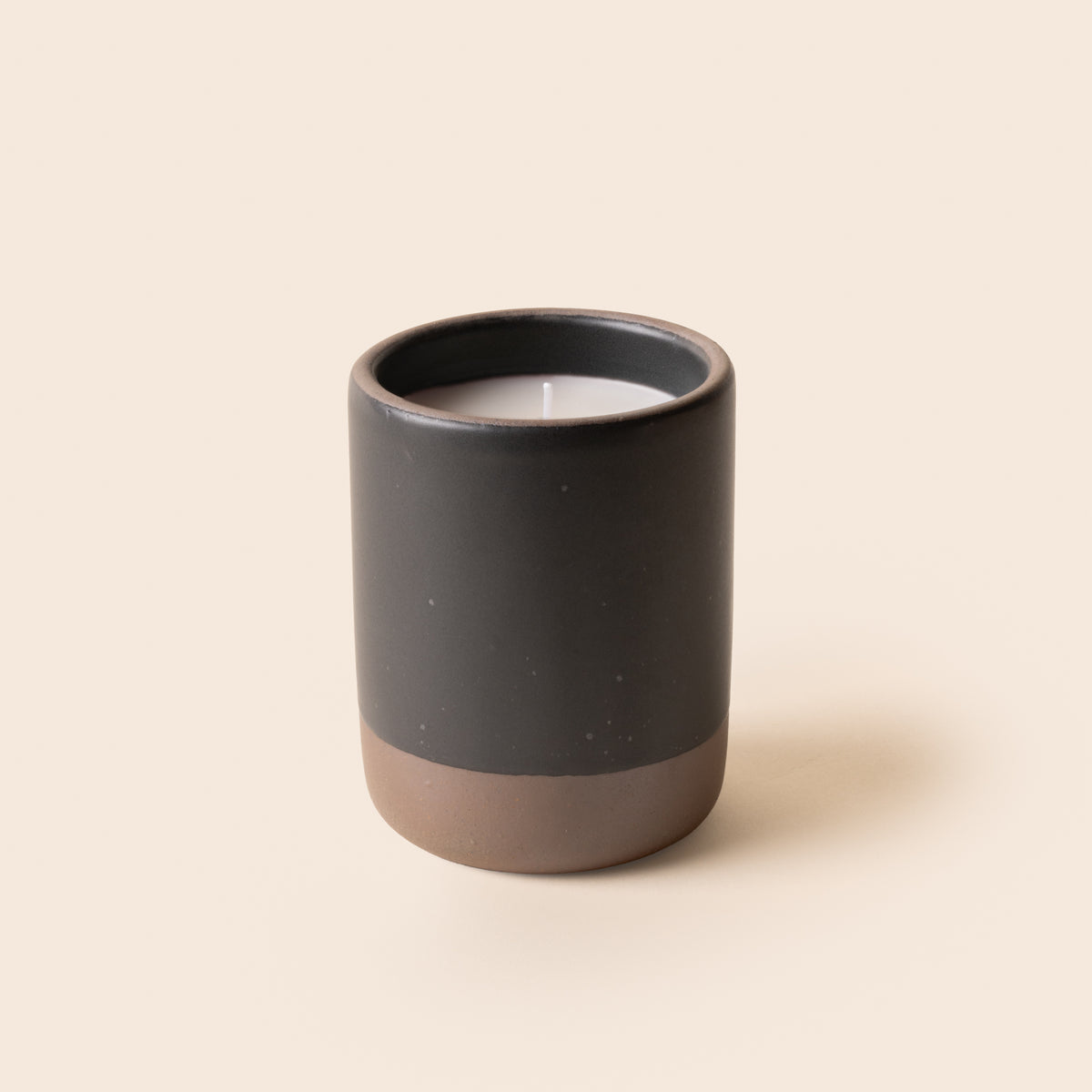 Large ceramic vessel in a black color with candle inside.