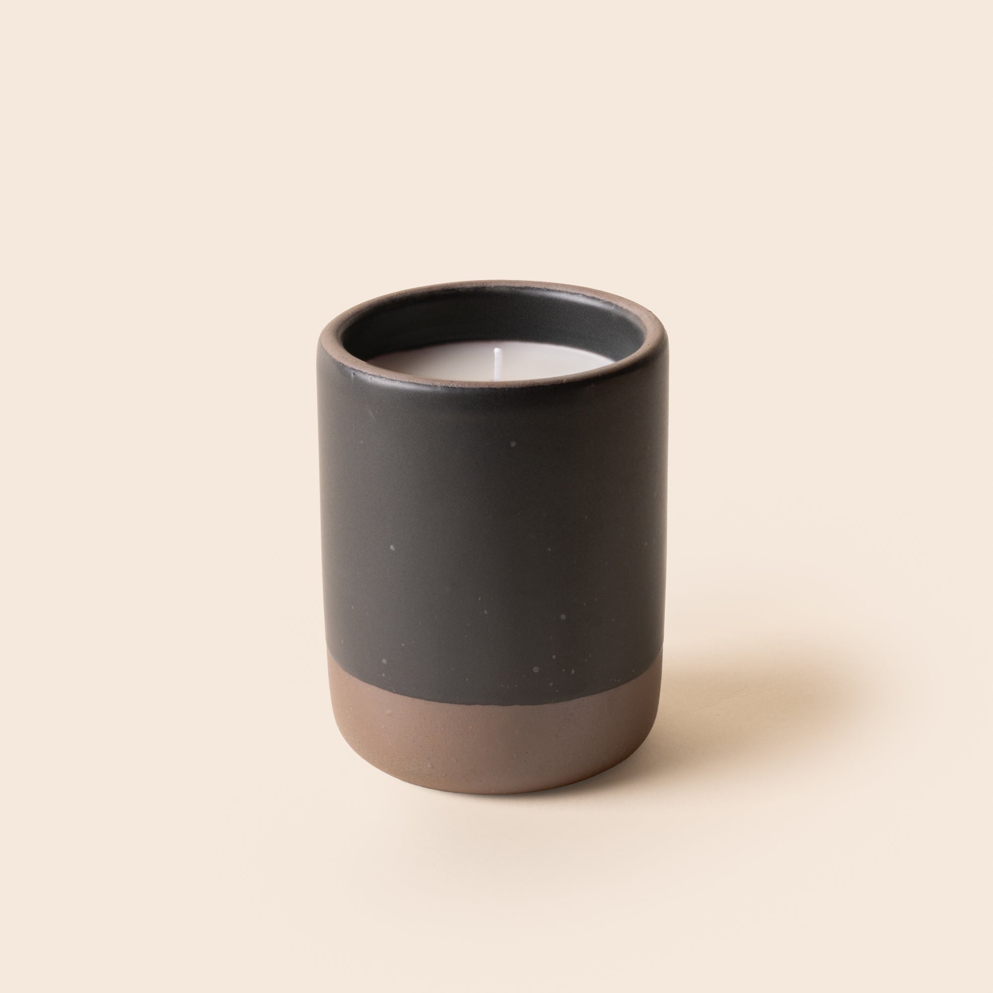 Large ceramic vessel in a black color with candle inside.
