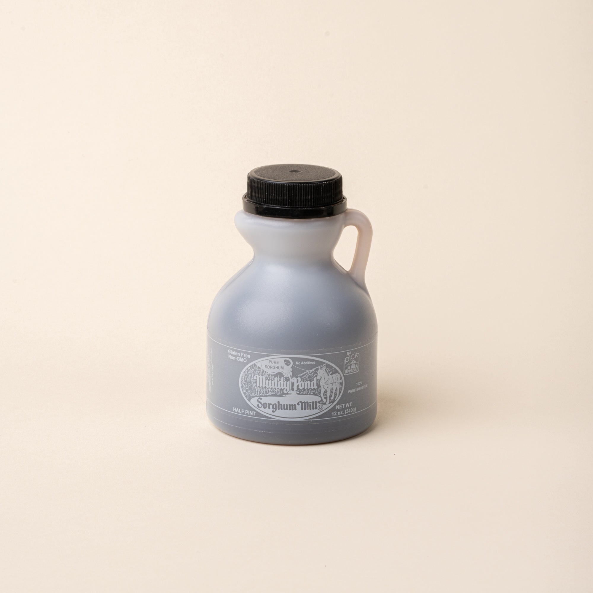Bottle of Muddy Pond Sorghum Mills pure sorghum syrup with black cap on a plain white background.