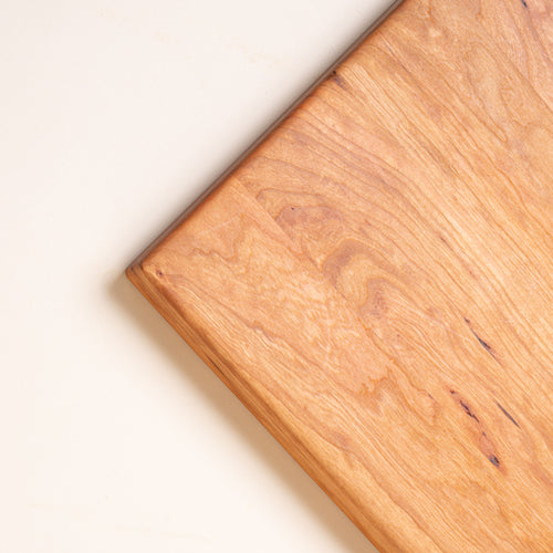 Closeup of a corner of a rectangular cherry cutting board