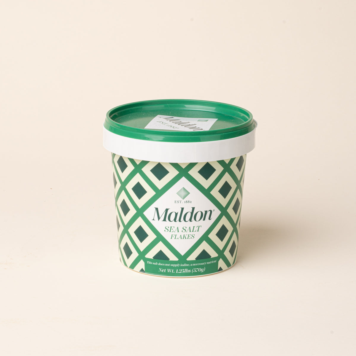 Maldon Sea Salt Flakes in a cylindrical container with a green lid and green-and-white geometric patterned label