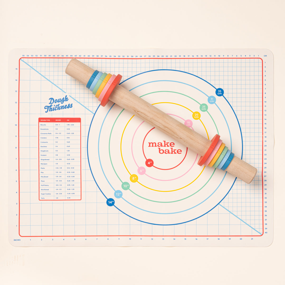 Wooden rolling pin with colorful thickness rings on a silicone pastry mat with measurement guides.