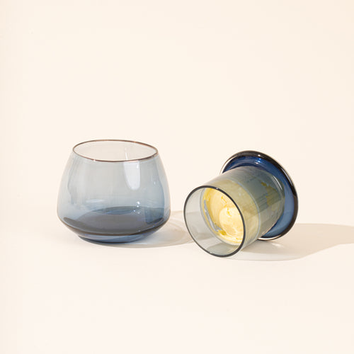 The top of the blue clear butter keeper filled with butter, resting to the right of the rounded base.