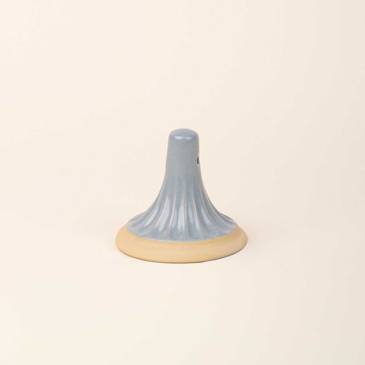 A light blue ceramic cookie stamp with a cream colored base