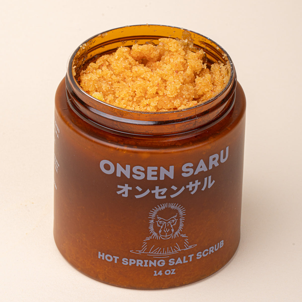 An open amber jar of Onsen Saru Hot Spring Salt Scrub