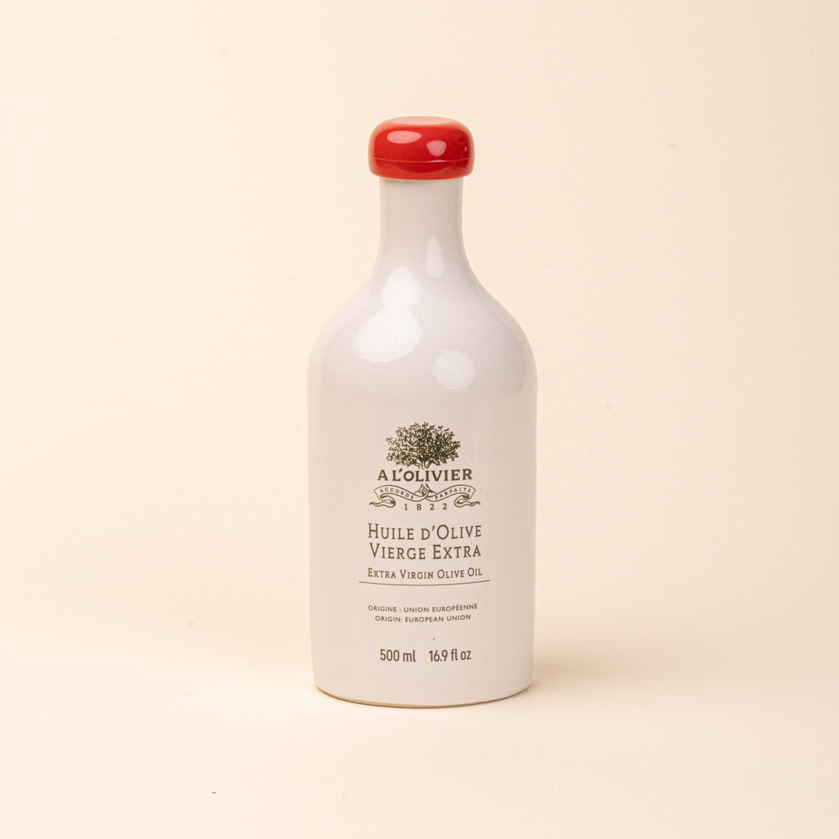 White ceramic bottle of A L'Olivier extra virgin olive oil with a red cap and gold lettering, 500 ml.