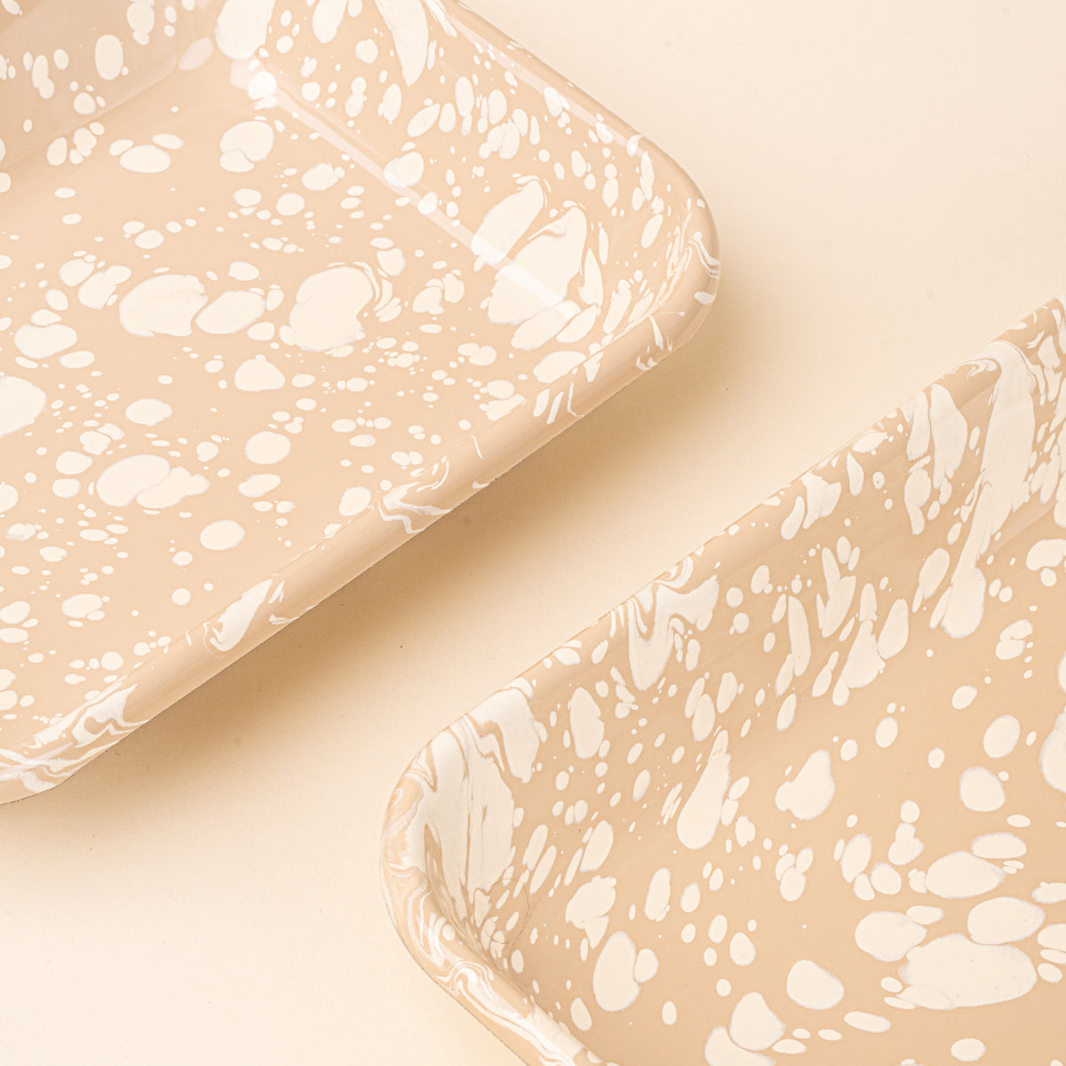Closeup of rectangular baking dishes in a neutral tan color with off-white splattered pattern