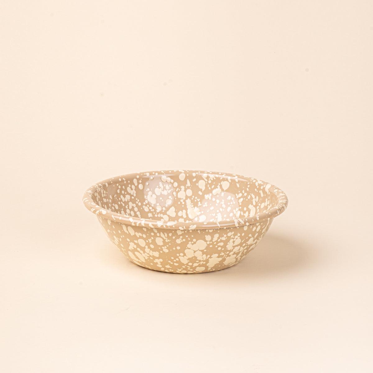 A large enamel bowl in neutral tan color with off-white splatter pattern.