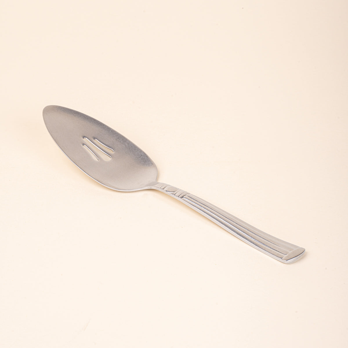Vintage-inspired silver pie server with a slotted blade and fluted handle.