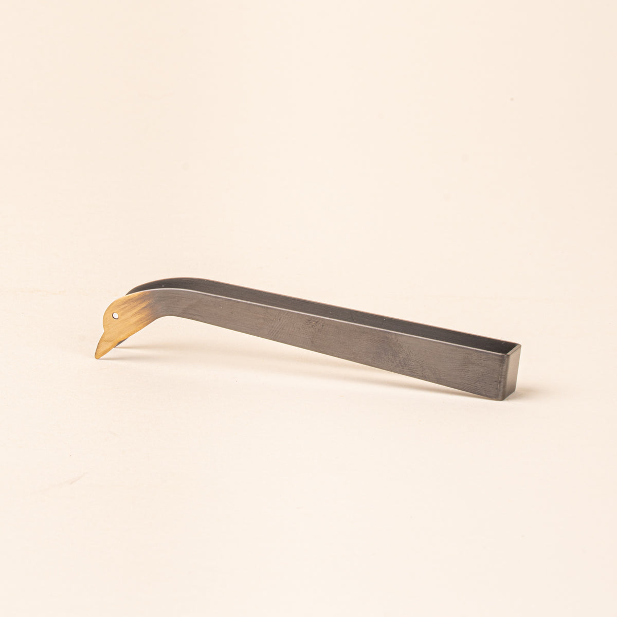Simple steel clamp candle snuffer with a tip that is a duck head silhouette with eyes
