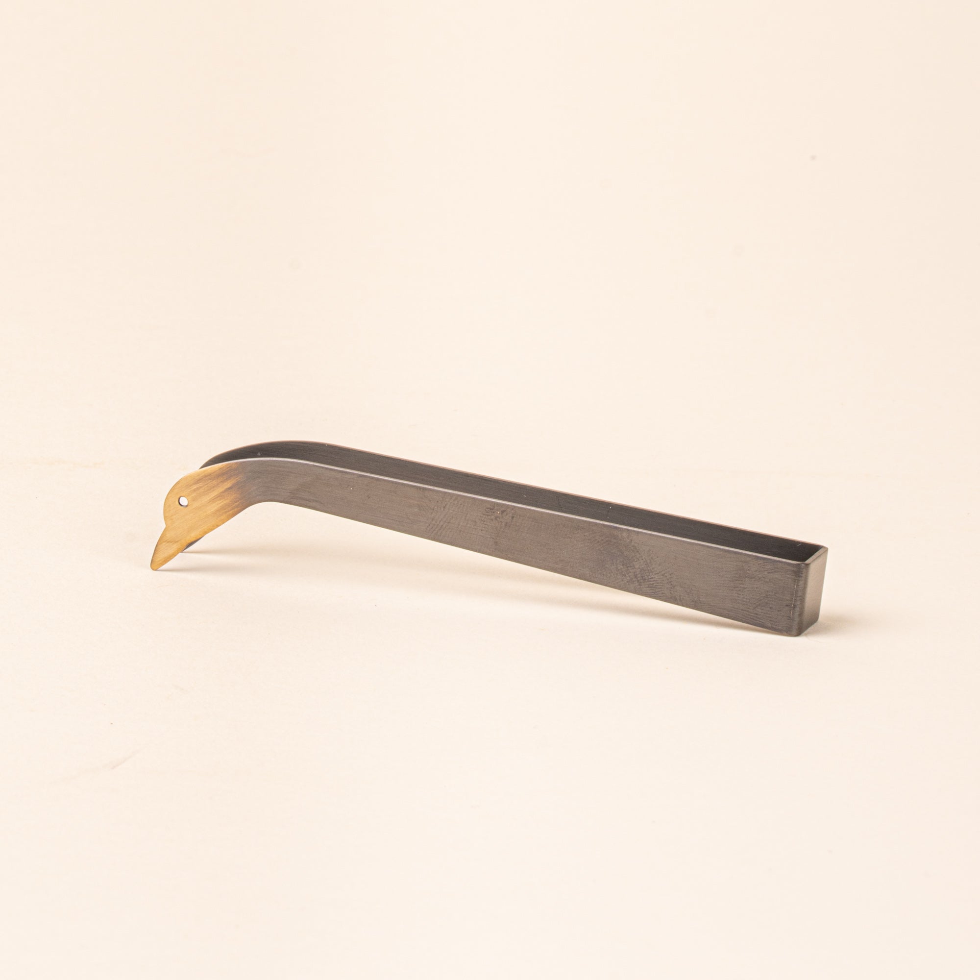 Simple steel clamp candle snuffer with a tip that is a duck head silhouette with eyes
