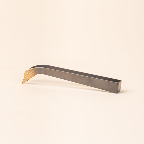 Simple steel clamp candle snuffer with a tip that is a duck head silhouette with eyes