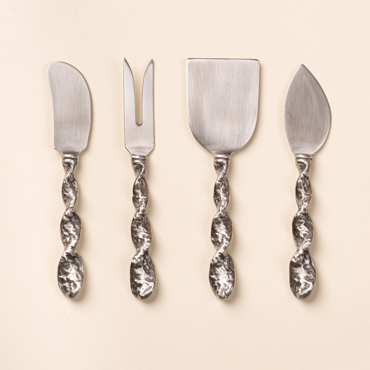 Four stainless steel cheese utensils with textured twisted handles, including knives, a fork, and a cheese server.