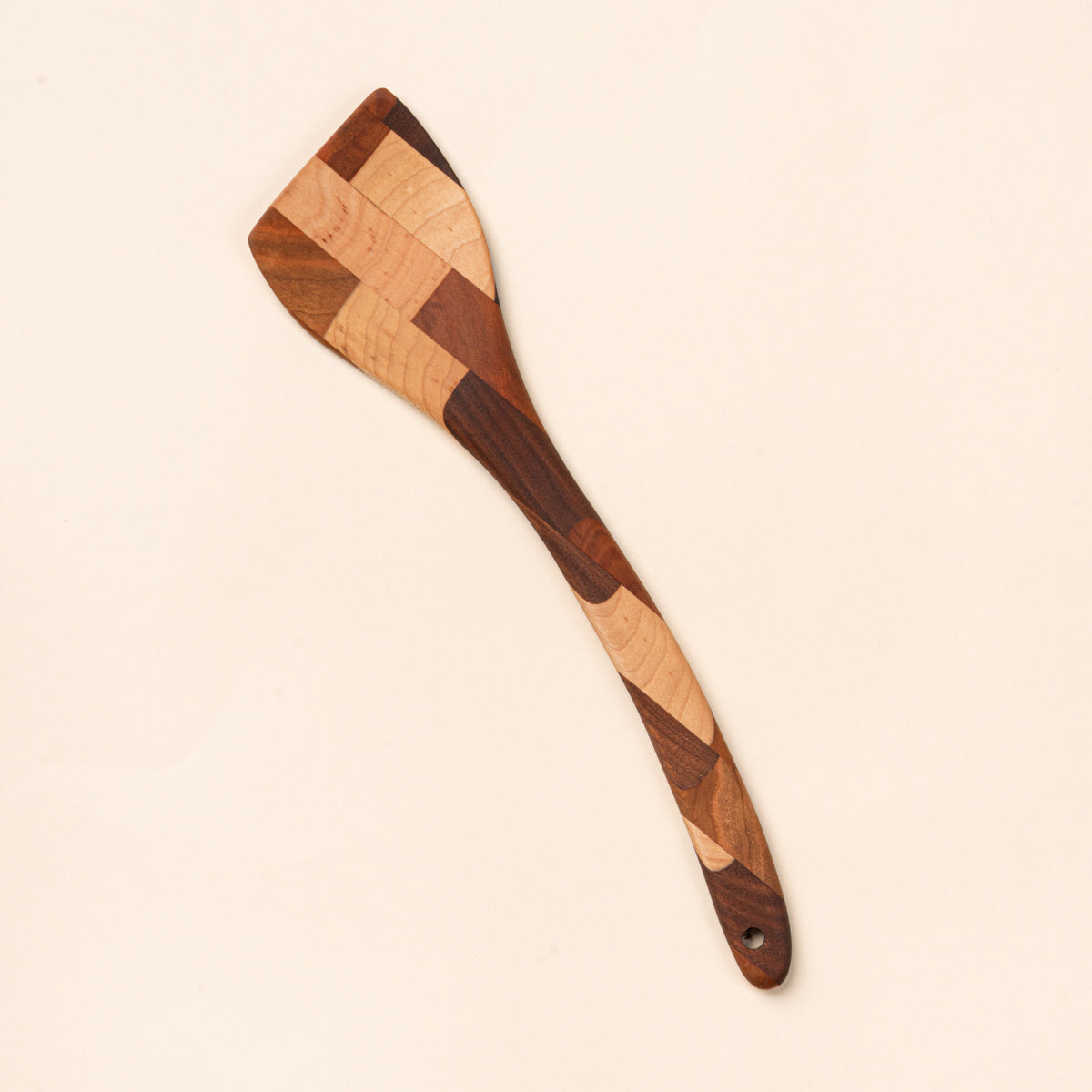 Mixed wood spatula with a slanted head and a hole at the bottom 